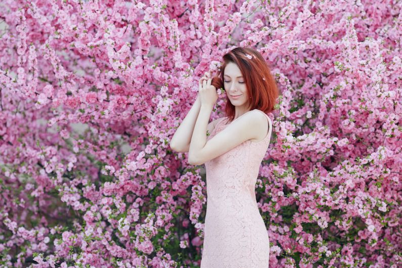 Spring Fashion - woman in white sleeveless dress standing beside pink flowers