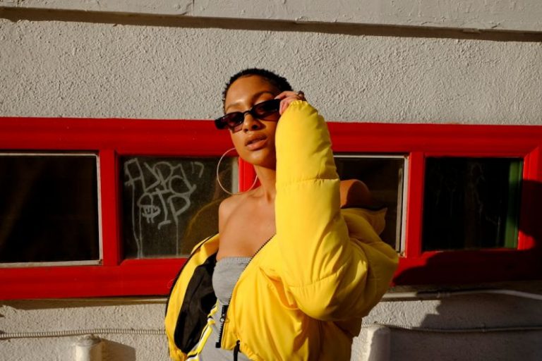 Streetwear Fashion - woman holding her sunglasses
