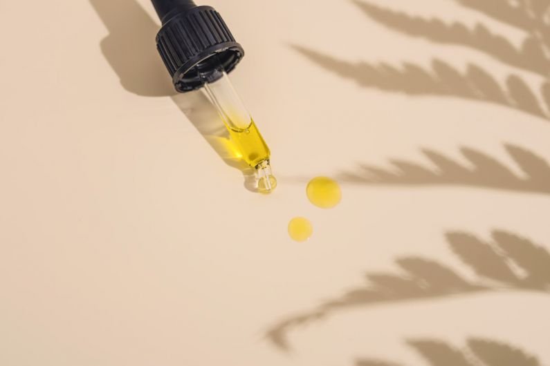 Skincare Products - a dropper bottle filled with yellow liquid sitting on top of a table