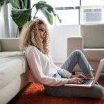 Laptop Home - woman sitting on floor and leaning on couch using laptop